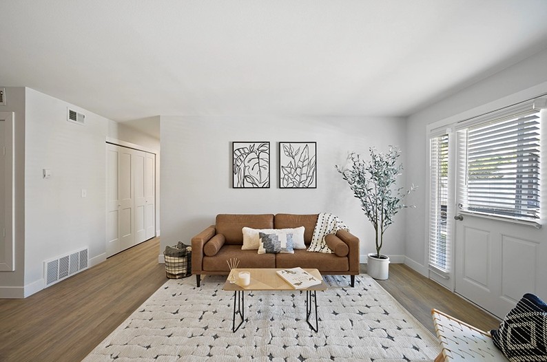 Model living room with hardwood style flooring at The Alpine