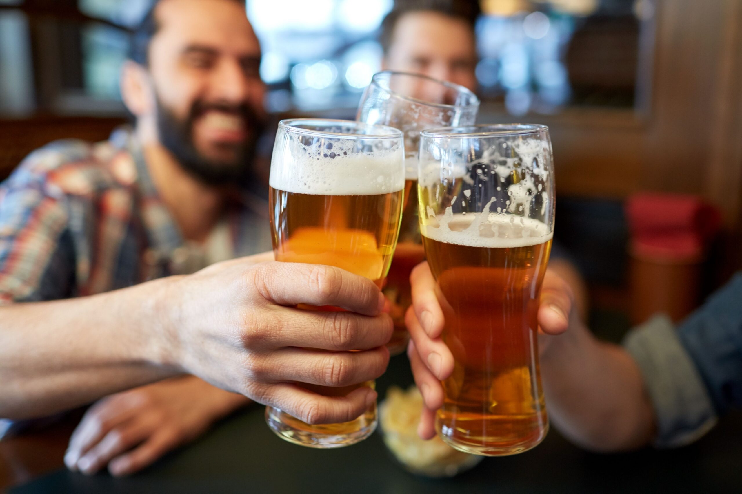 friends clinking glasses of beer scaled